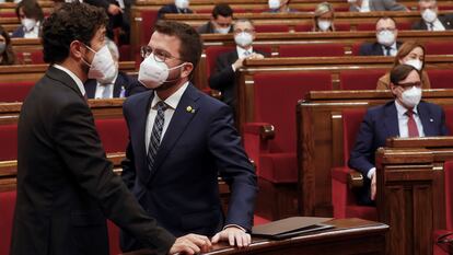 El líder de ERC, Pere Aragonès, conversa con el consejero de Territorio Damià Calvet, a la izquierda, en el Parlament catalán.