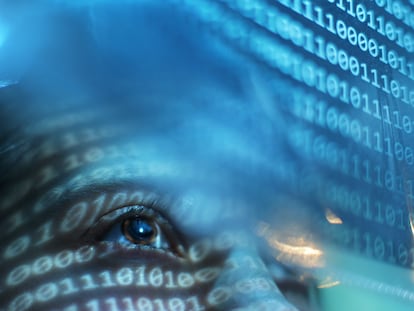 A woman looking at a blue screen with binary code.