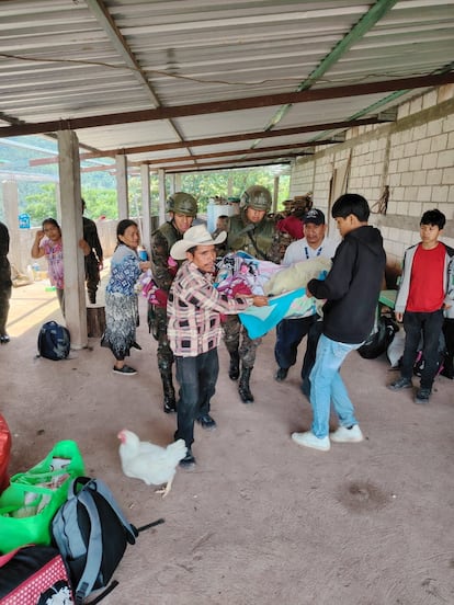 Mexicanos que cruzaron la frontera hacia Guatemala en busca de refugio después de huir de la violencia en el estado de Chiapas, ayudan a una persona en Cuilco. 
