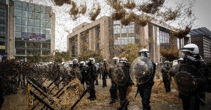 Una protesta de agricultores lanza heno a la polic&iacute;a belga frente a la sede de la Comisi&oacute;n Europea, en Bruselas.&nbsp;