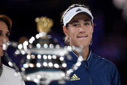 Muguruza observa el trofeo de campeona del Open de Australia.