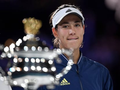 Muguruza observa el trofeo de campeona del Open de Australia.