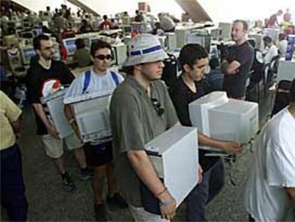 Participantes en el Campus Party recogen sus ordenadores para volver a casa.