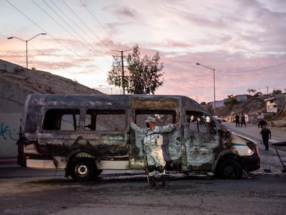 Un elemento de la Guardia Nacional resguarda la zona donde un grupo delictivo incendió un vehículo, en Tijuana, Estado de Baja California, el 12 de agosto de 2022.