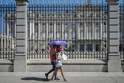 Dos ciudadanos se resguardan del calor con un paraguas este verano en Madrid.