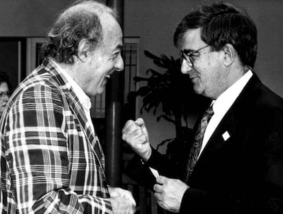 El artista Eduardo Arroyo (a la izquierda) y Ernest Lluch hablan durante un curso de la Universidad Internacional Menéndez Pelayo de Santander (Cantabria), en 1994.