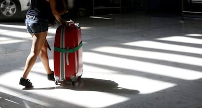 Una mujer transporta una maleta en el aeropuerto Afolfo Su&aacute;rez Madrid-Barajas.