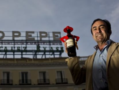 Pedro Pérez-Solero posa en la Puerta del Sol frente al anuncio de su abuelo, Luis Pérez Solero.