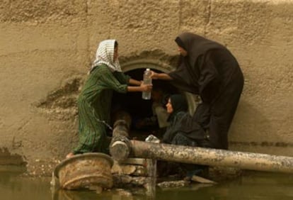 Un grupo de mujeres iraquíes llena botellas de agua en una tubería en Nasiriya, el pasado 25 de abril.