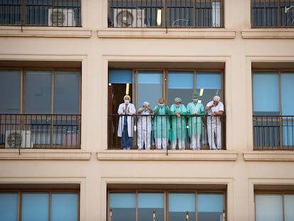 Personal sanitario del Hospital Regional de Málaga agradece desde un balcón los aplausos de la ciudadanía.