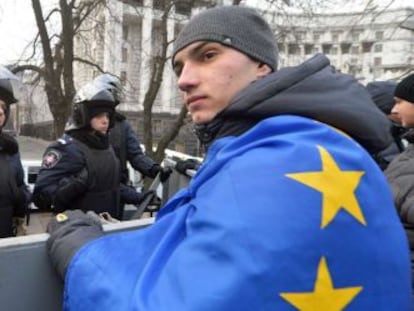 Un manifestante con una bandera europea frente a una barrera policial en Kiev.