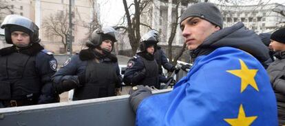 Un manifestante con una bandera europea frente a una barrera policial en Kiev.