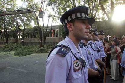 Un grupo de policías municipales forma una barrera para impedir que los vecinos paralicen la tala de las acacias.