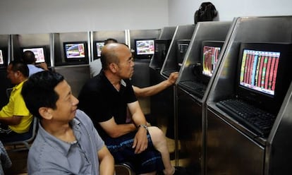 Dos inversores observan en sus pantallas la evolución de los mercados chinos.