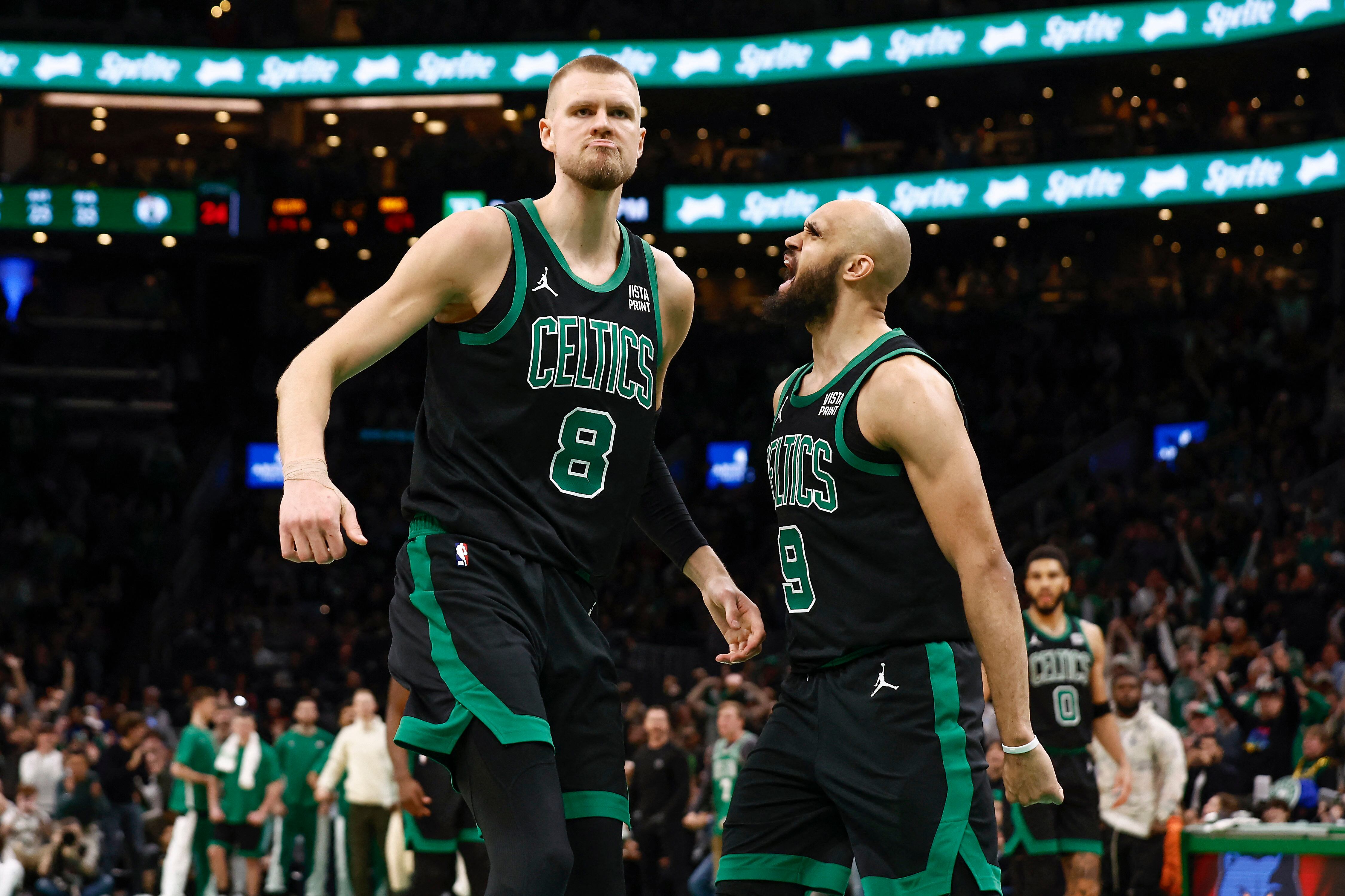 Derrick White (9) y Kristaps Porziņģis (8) celebran un mate contra los Milwaukee Bucks.