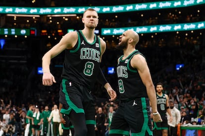 El escolta de los Boston Celtics Derrick White (a la derecha) celebra un mate del pívot Kristaps Porziņģis en un partido contra los Milwaukee Bucks