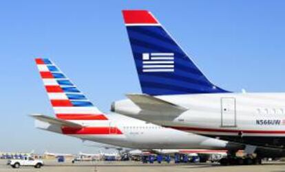 Fotografía fechada el 14 de febrero de 2013 que muestra un avión de la compañía US Airways (d) junto a uno de la compañía American Airlines (i), en el aeropuerto internacional de Ft. Worth (Texas), EE.UU. EFE/Archivo