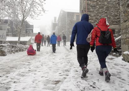 Visitantes caminan en las calles heladas de O Cebreiro (Lugo), el 14 de enero.