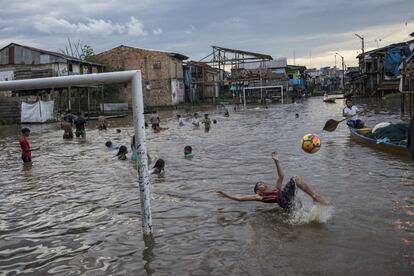 Niños juegan en un área inundada de la comunidad de Belén en Iquitos, Perú, el 20 de marzo de 2021. Históricas lluvias dejaron la zona bajo una gran inundación por al menos 15 días.