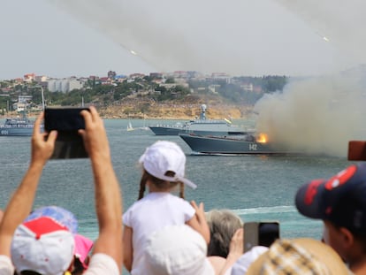 People watch as Russian warships fire missiles during the Navy Day parade in the Black Sea port of Sevastopol, Crimea July 26, 2020. REUTERS/Alexey Pavlishak