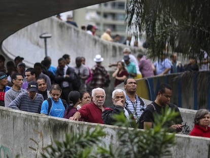 Votantes frente a la favela de Rocinha en Río de Janeiro (Brasil).