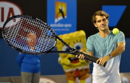 Federer usa una raqueta gigante en una exhibición con niños.