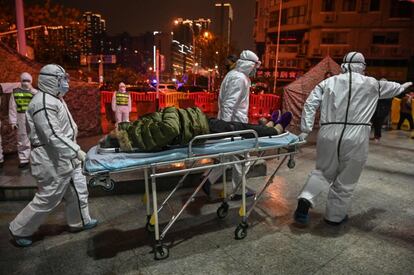 Personal sanitario traslada a una mujer al hospital de la Cruz Roja de Wuhan. La imagen es del 25 de enero, fecha en la que el Gobierno chino daba 41 muertos como cifra oficial de fallecidos por el nuevo coronavirus.