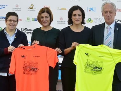 Organizadores y patrocinadores de la carrera posan con las camisetas oficiales.