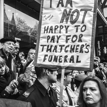 Una mujer sujeta una pancarta durante el cortejo funebre de la ex preimera ministra, Margaret Thatcher, por las calles de Londres. Imagen realizada con un iPhone.