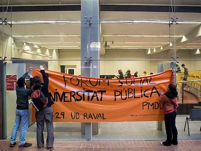 Tres estudiantes colocan una pancarta en la Pompeu Fabra en defensa de la universidad pública.