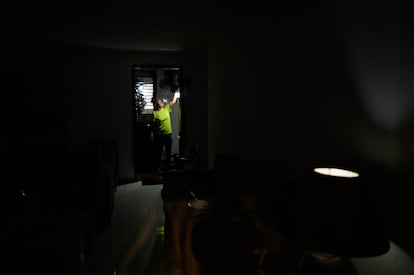 Carolina González prende un bombillo recargable en la cocina de su casa durante una falla de servicio eléctrico que dejó un sector sin luz por varios días en la urbanización el Cafetal, en Caracas, el 7 de Septiembre de 2023.