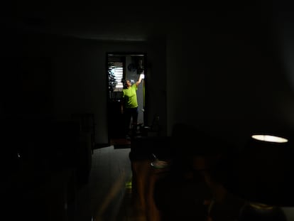 Carolina González prende un bombillo recargable en la cocina de su casa durante una falla de servicio eléctrico que dejó un sector sin luz por varios días en la urbanización el Cafetal, en Caracas, el 7 de Septiembre de 2023.