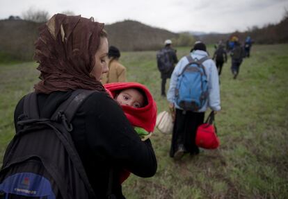 Una mujer lleva en brazos a su bebé tras haber cruzado el río entre Grecia y Macedonia. Miles de migrantes continúan caminando hacia el norte de Europa. La mayoría quiere alcanzar Alemania o Suecia.