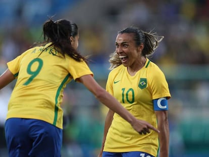 Marta e Andressa comemoram gol na estreia da seleção.