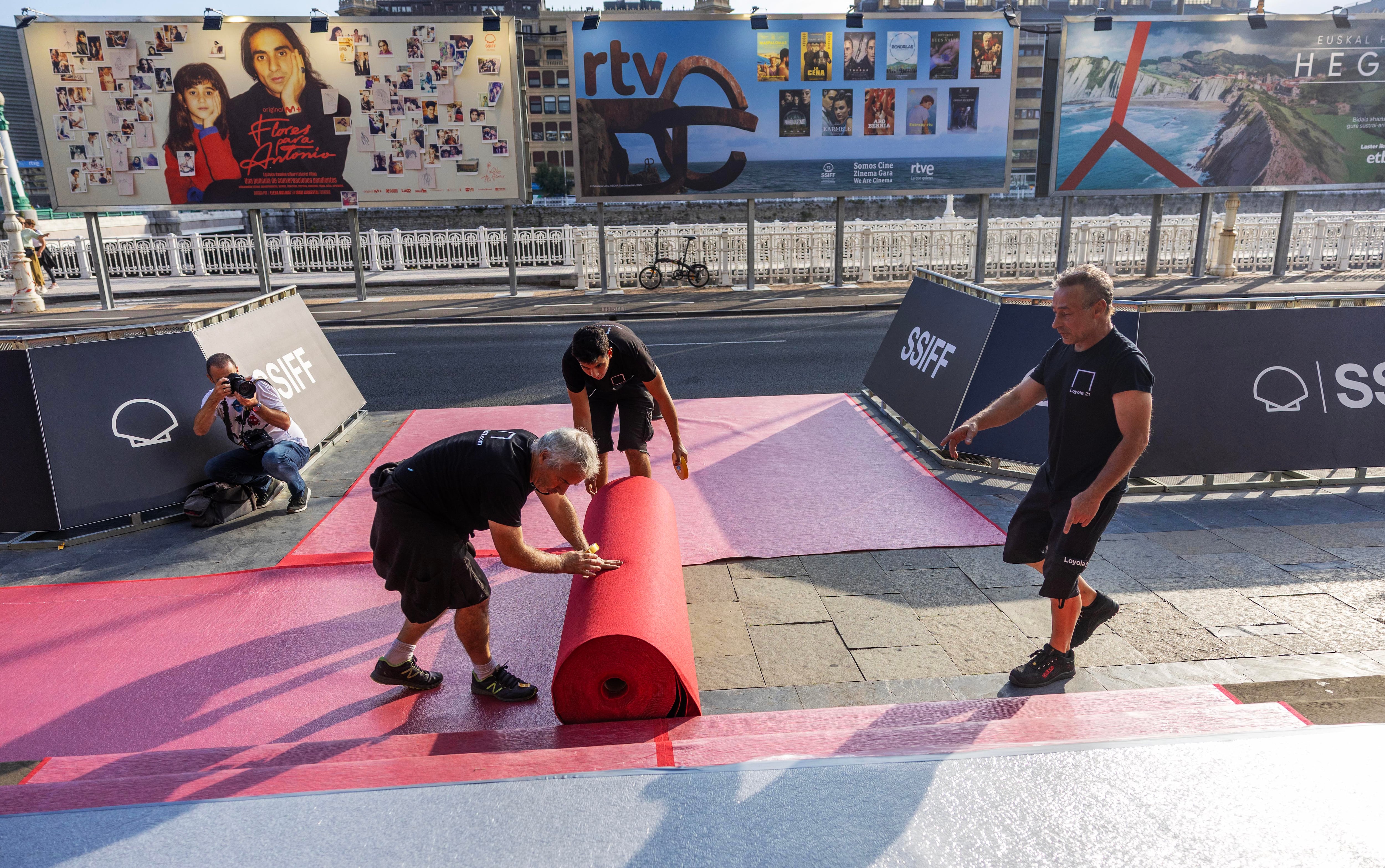 Colocación de la alfombra roja en la puerta del teatro Victoria Eugenia la víspera de la inauguración del certamen. 