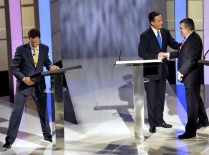 Gordon Brown (derecha) y David Cameron se saludan tras el debate del jueves. A la izquierda, Nick Clegg.