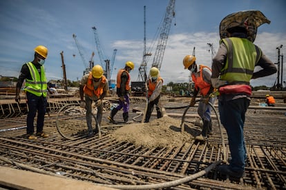 Varios obreros trabajan bajo órdenes de un capataz asiático en la ampliación del puerto de Tanga para poder atender a los futuros barcos petroleros que vendrán a cargar crudo para exportarlo, el pasado 14 de septiembre.