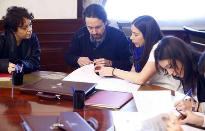 El secretario general de Podemos, Pablo Iglesias, firma su acta de diputado en el Congreso acompañado por la también diputada electa y miembro de la Mesa de Coordinación de Podemos, Irene Montero (d).