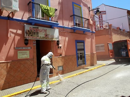 An Algeciras city worker disinfects the outside of a hostel following a coronavirus outbreak.