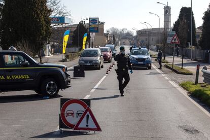 Las autoridades italianas han blindado cinco regiones del norte de la península para intentar frenar la propagación del coronavirus tras de la muerte este lunes de una sexta persona, un paciente oncológico. En la imagen, agentes de la policía italiana cierran este lunes una carretera de Casalpusterlengo, una de las localidades del norte de Italia bajo encierro debido al coronavirus.