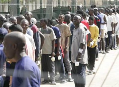 Inmigrantes subsaharianos hacen cola para su turno de comida en un centro de Melilla, en 2005.