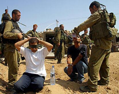 Soldados israelíes vigilan a palestinos detenidos ayer en Beit Yala, en la franja de Gaza.