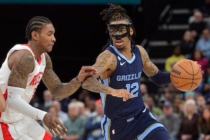 Memphis Grizzlies guard Ja Morant (12) handles the ball against Houston Rockets guard Kevin Porter Jr. (3) in the second half of an NBA basketball game Wednesday, March 22, 2023, in Memphis, Tenn.