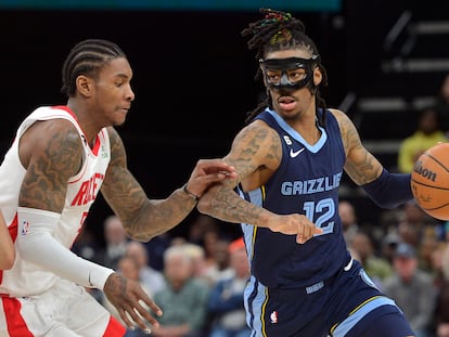 Memphis Grizzlies guard Ja Morant (12) handles the ball against Houston Rockets guard Kevin Porter Jr. (3) in the second half of an NBA basketball game Wednesday, March 22, 2023, in Memphis, Tenn.