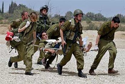 Soldados israelíes evacúan a uno de los militares heridos en la ruta de Kisufim, en el acceso a Gush Katif.