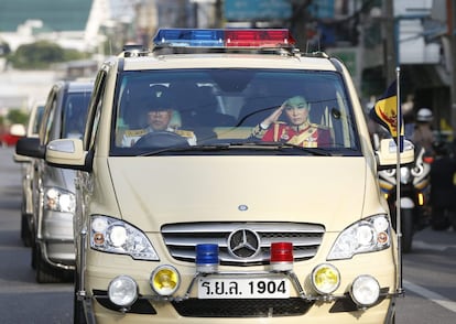 La consorte del príncipe heredero Maha Vajiralonkorn, Suthida Vajiralongkorn na Ayudhaya (d) saluda en la caravana en la que viaja el cuerpo del rey Bhumibol Adulyadej tras su muerte tras abandonar el hospital de Siriraj en Bangkok.