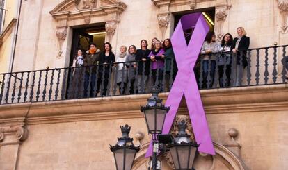 El Ayuntamiento de Palma cuelga un gran lazo morado en su fachada con motivo del D&iacute;a Internacional de la Mujer.
