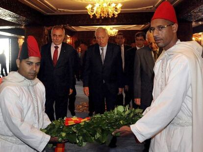 Jos&eacute; Manuel Garc&iacute;a-Margallo (c), se prepara para depositar un ramo de flores en las tumbas del rey Hasan II de Marruecos y de su padre, Mohamed V, en el mausoleo Mohamed V en Rabat.