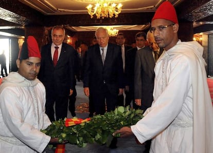 Jos&eacute; Manuel Garc&iacute;a-Margallo (c), se prepara para depositar un ramo de flores en las tumbas del rey Hasan II de Marruecos y de su padre, Mohamed V, en el mausoleo Mohamed V en Rabat.