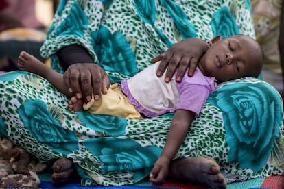 La pequeña Khadiyatou, de 11 meses, duerme en el regazo de su madre en el pueblo de M’Beckaire. La niña ha recibido apoyo nutricional de la ONG.